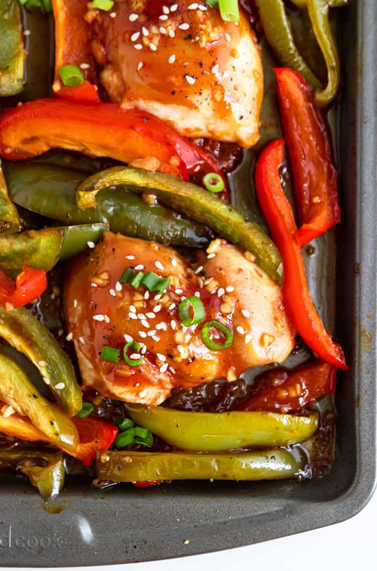 Chicken and peppers on sheet pan with sesame seeds and green onion.