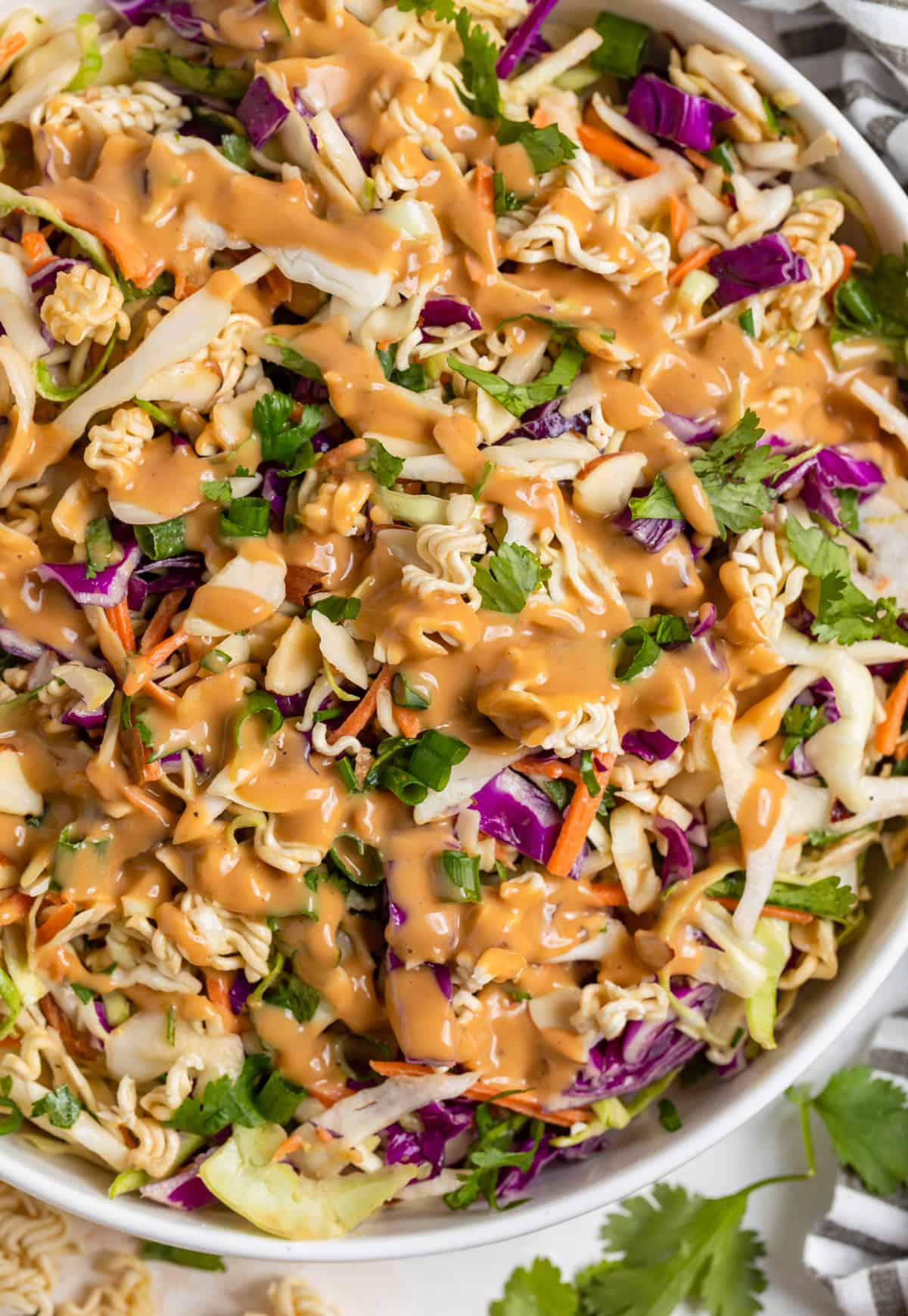 Ramen cabbage salad with peanut dressing drizzled over top.