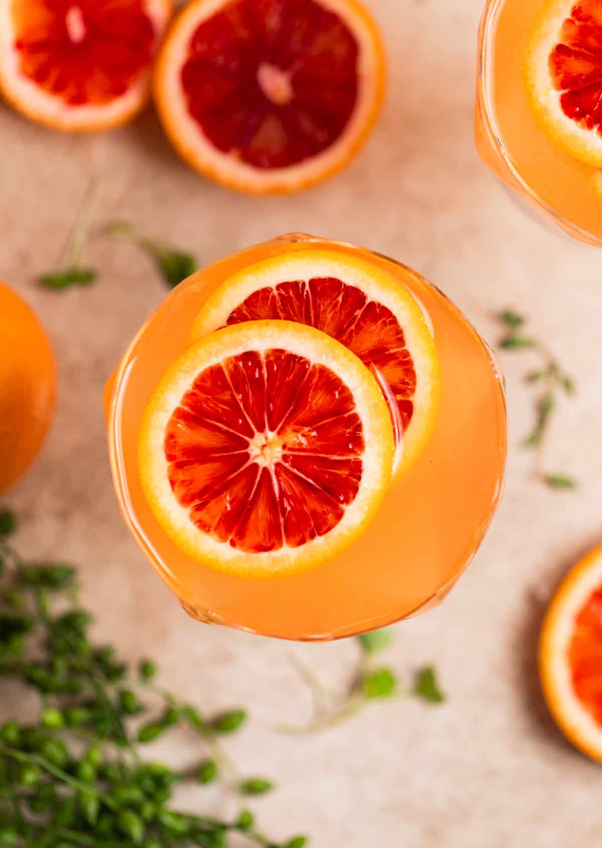 Overhead view of champagne cocktail with blood orange garnish.