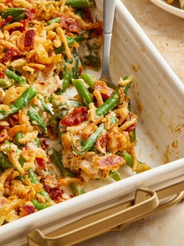 Bacon and green bean casserole in pan with serving spoon.