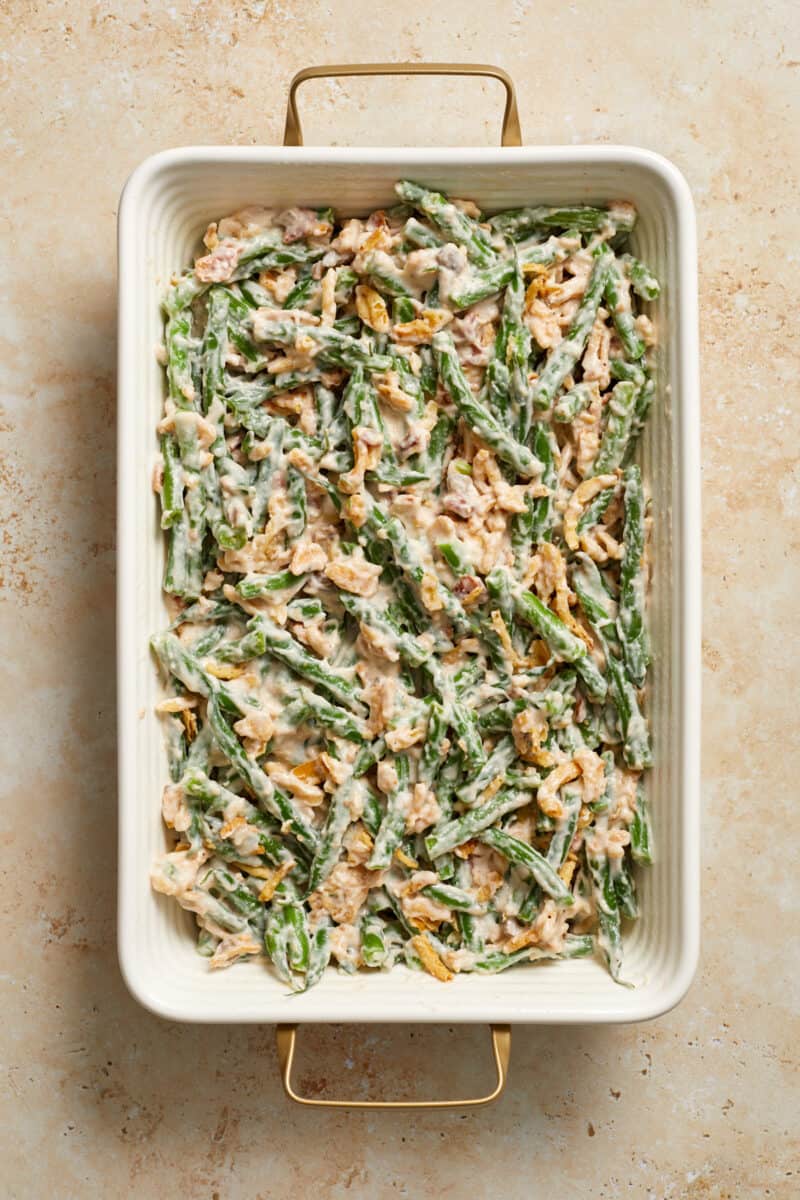 Bacon and green bean casserole mixture before baking in casserole dish.