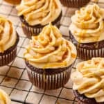 Chocolate espresso cupcakes topped with caramel buttercream on cooling rack.