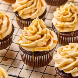 Chocolate espresso cupcakes topped with caramel buttercream on cooling rack.