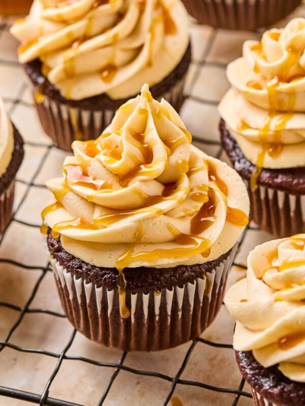 Chocolate espresso cupcakes topped with caramel buttercream on cooling rack.