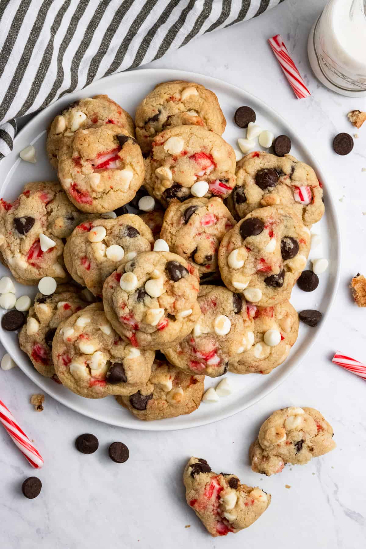 Cookies on plate with candy canes and milk.