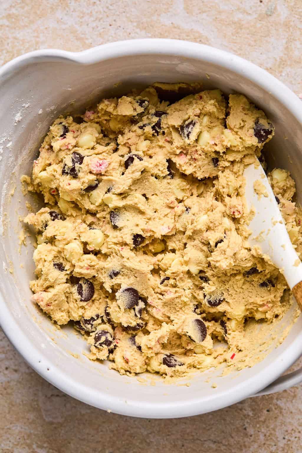 Prepared peppermint chocolate chip cookie dough in bowl with spoon.