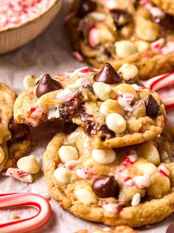 Peppermint chocolate chip cookies on parchment one on top of another with bite taken out.