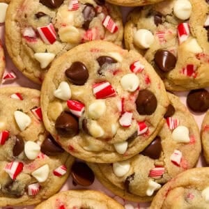 Peppermint chocolate chip cookies with white and dark chocolate chips and candy canes arranged on plate.