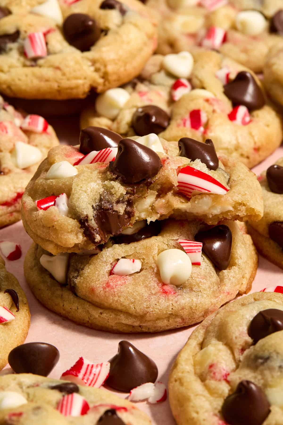 Chocolate chip peppermint cookie with bite taken out stacked on another cookie.