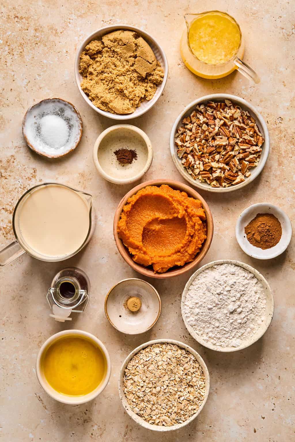 Pumpkin, eggs, brown sugar and crumble ingredients on surface.