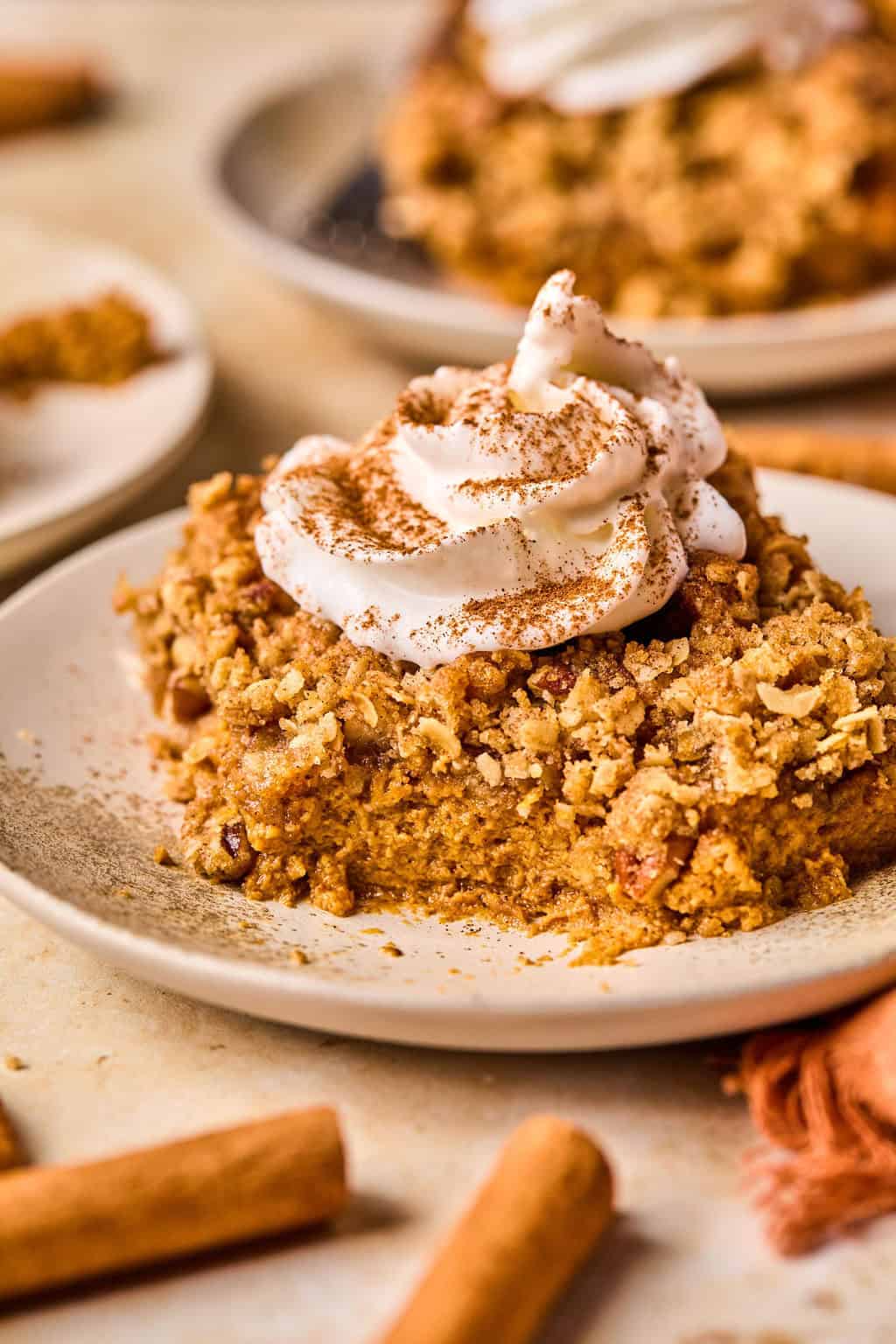 Piece of pumpkin crisp on dish with portion eaten.