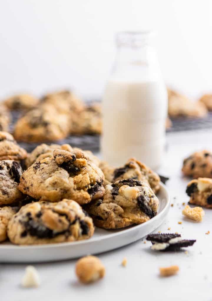 Loaded Cookies and Cream Cookies on plate with glass of milk.