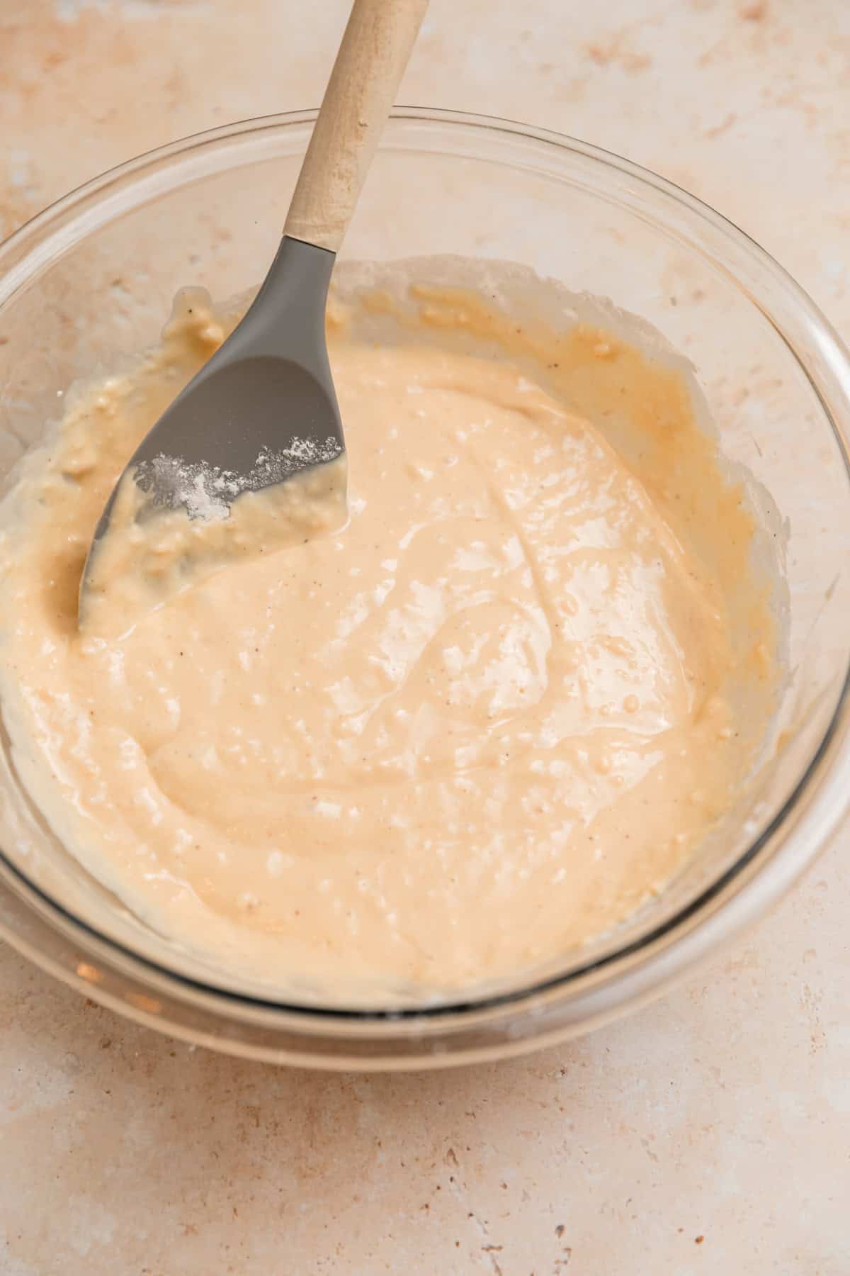 Greek yogurt donut batter in bowl with spatula.