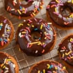 Chocolate glazed baked donuts on wire cooling rack.