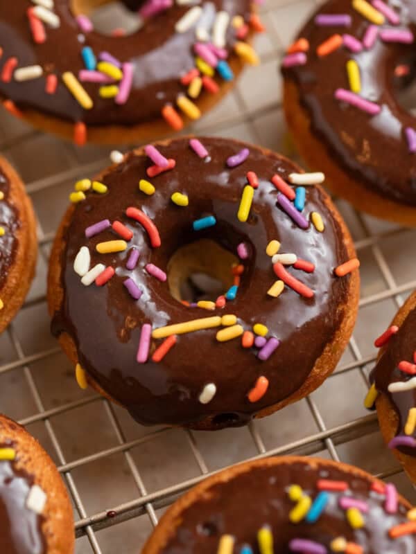 Chocolate glazed baked donuts on wire cooling rack.