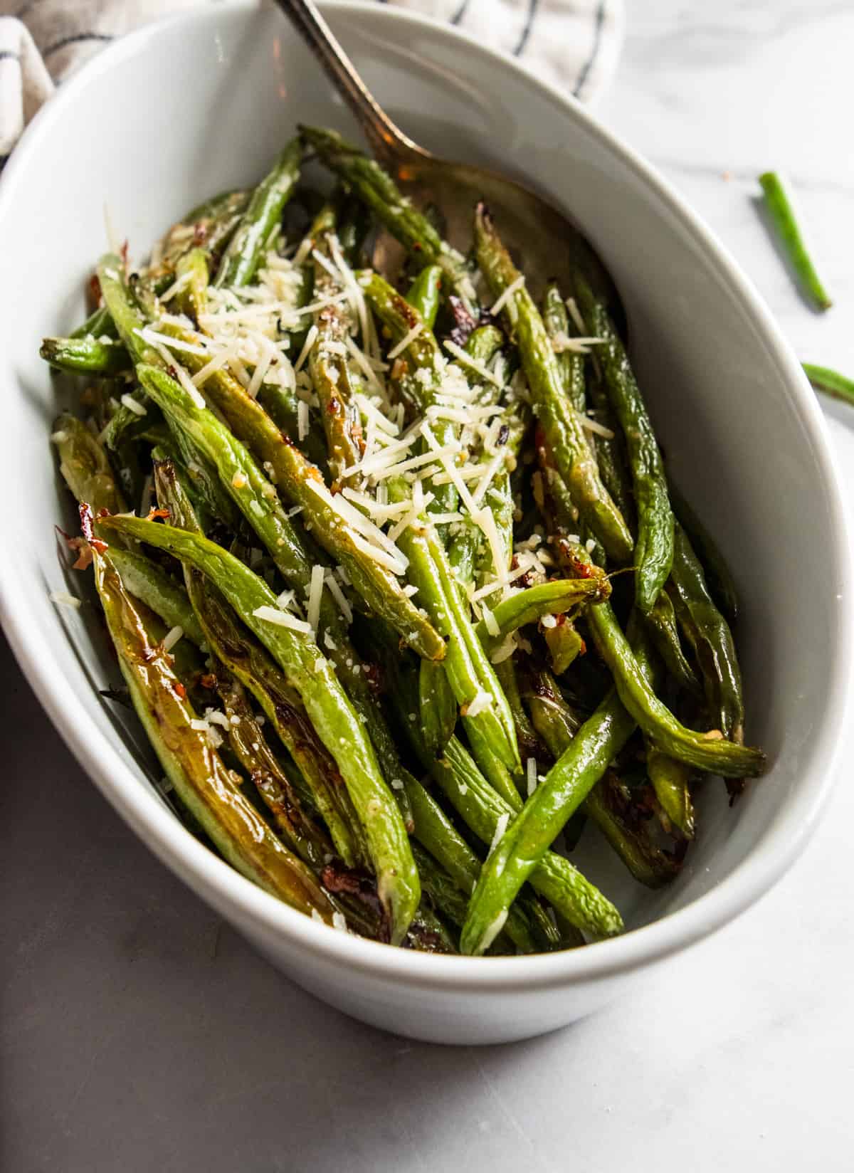 White serving bowl with roasted green beans.