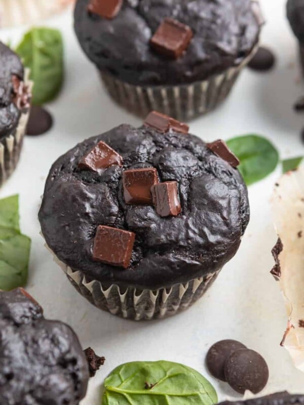 Chocolate spinach muffins with chocolate chips on top.