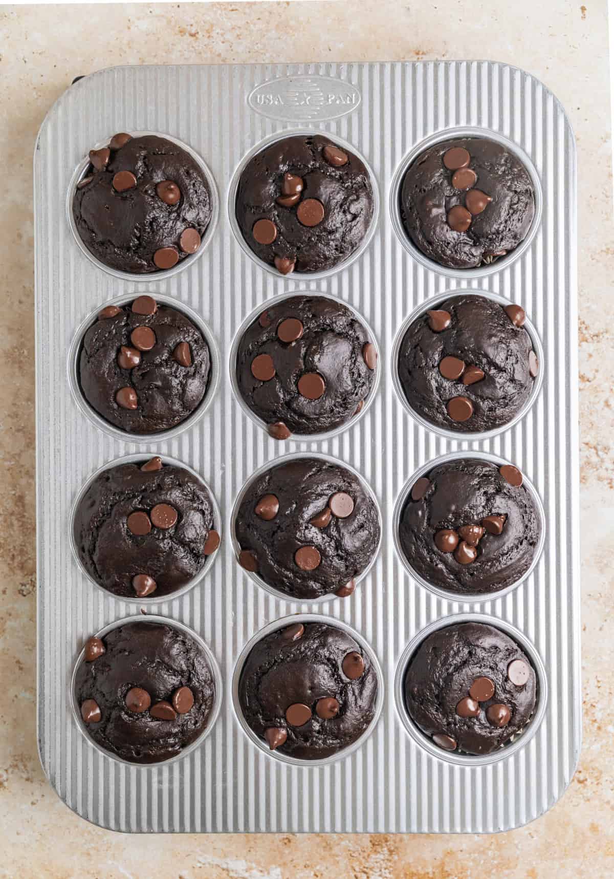 Baked chocolate spinach muffins in muffin tin.