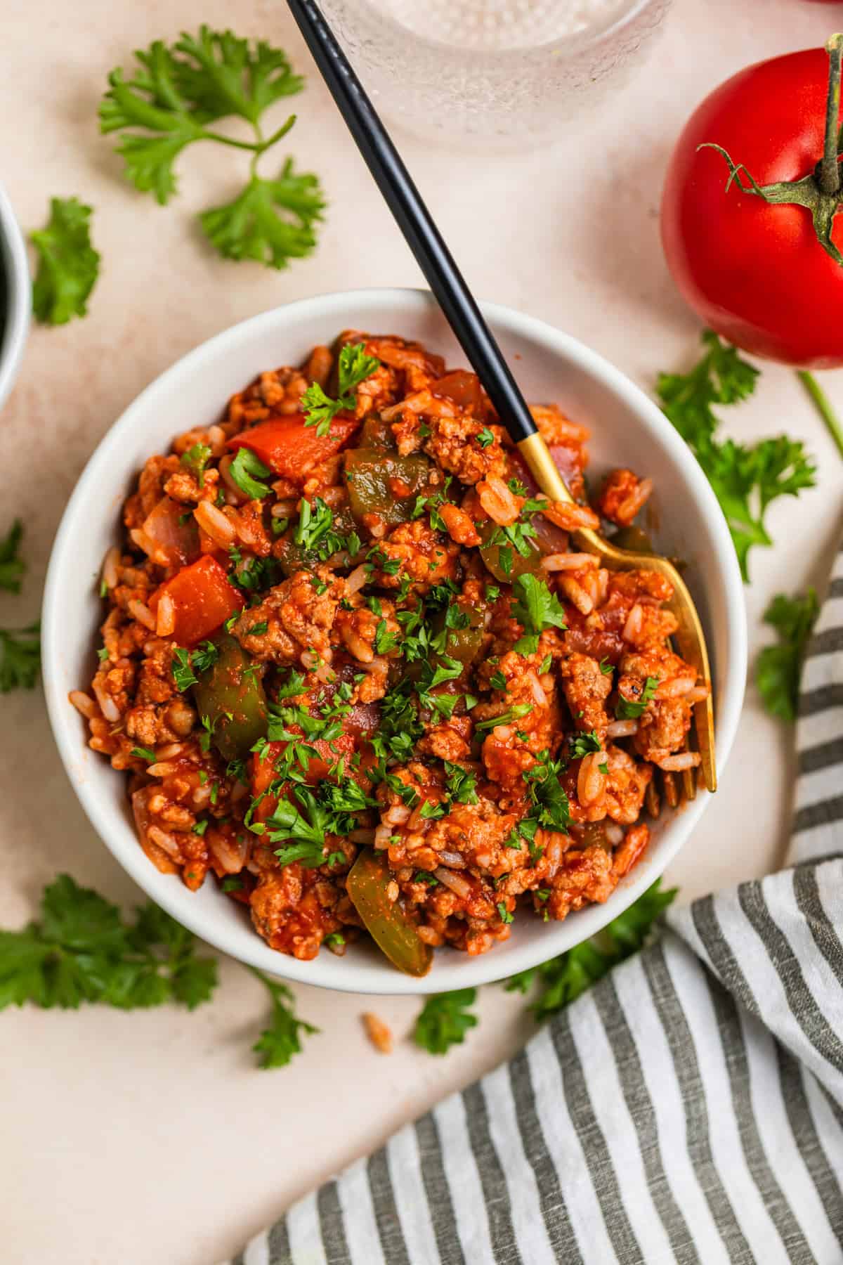 Bowl with turkey, pepper and rice dinner prepared and topped with parsley.