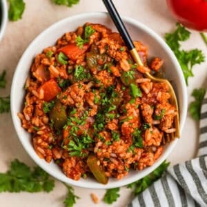 Bowl with serving of ground turkey skillet dinner with fork scooping into it.