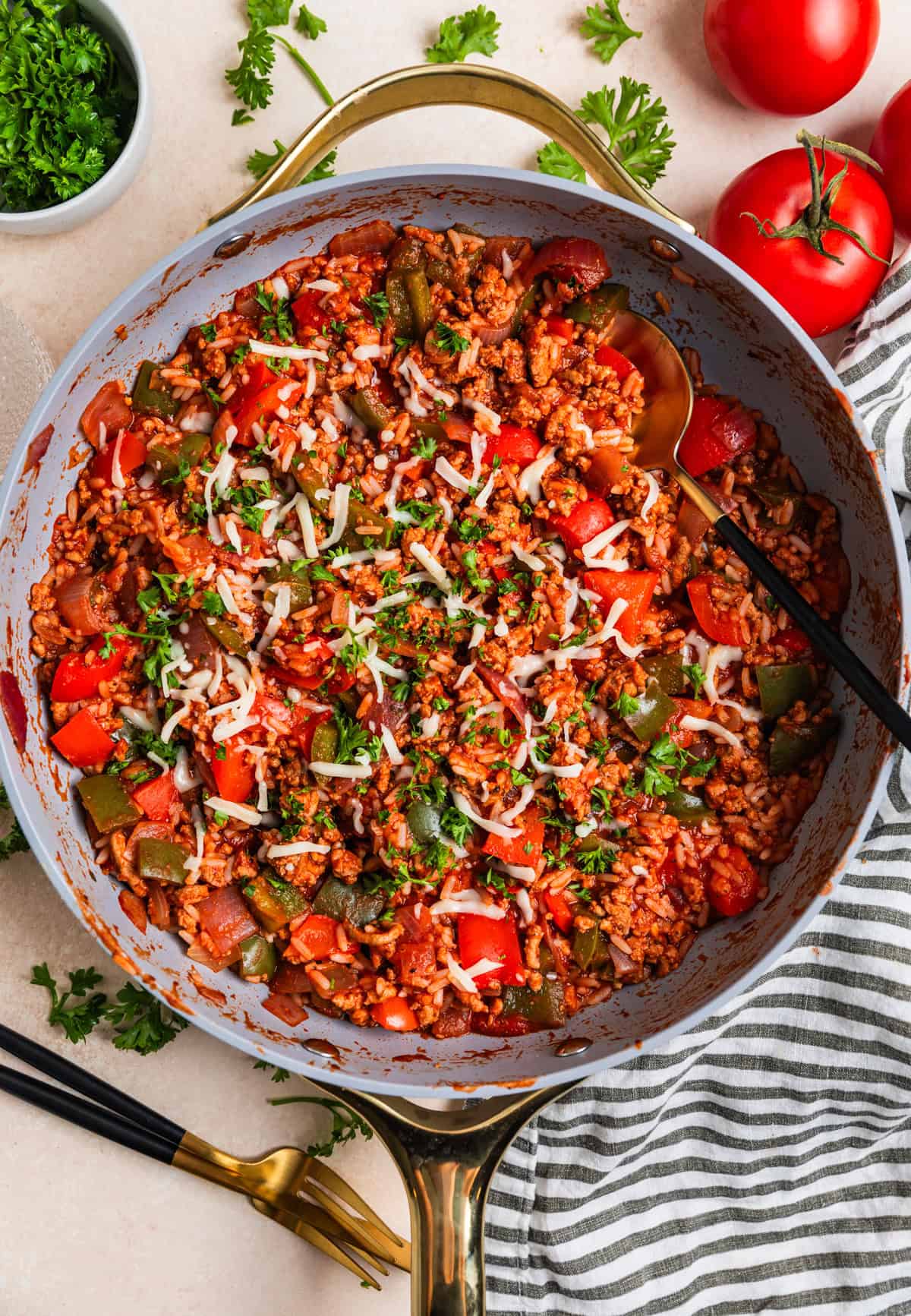 Skillet with prepared ground turkey skillet dinner recipe and topped with mozzarella and herbs.