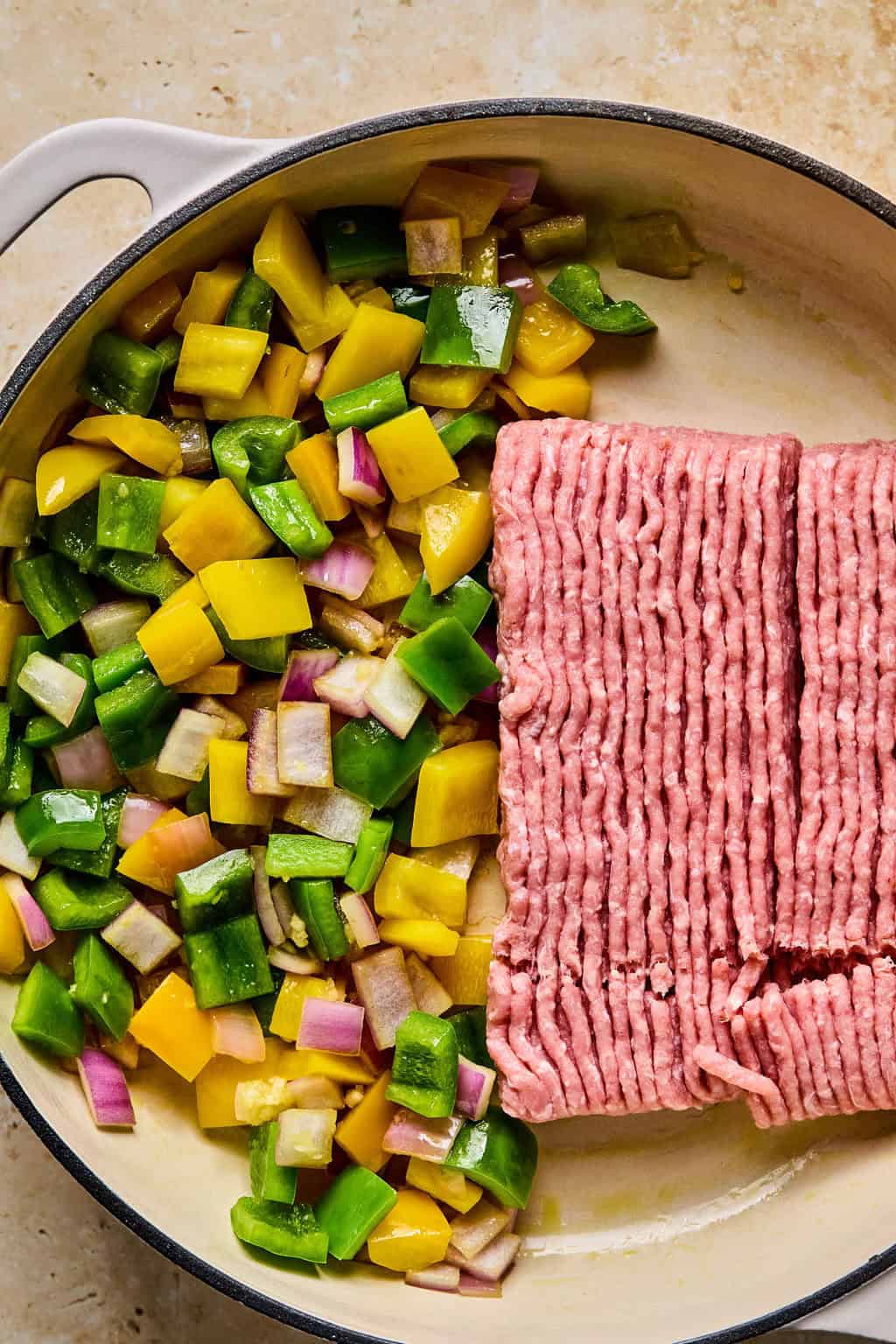 Ground turkey added to skillet with sautéed onions and peppers.