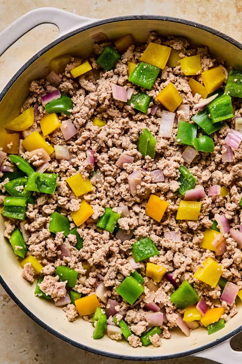 Browned ground turkey in skillet with peppers.