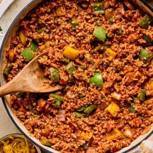 Simple ground turkey pepper skillet dinner in pan with wooden spoon.