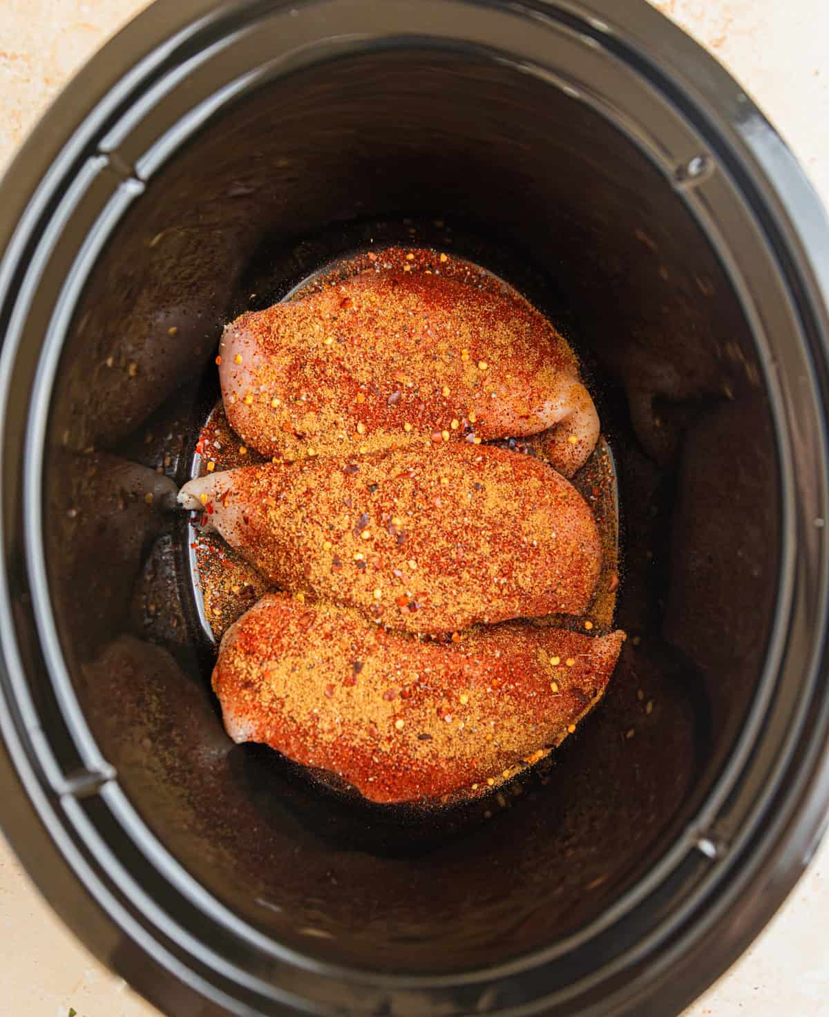 Seasoned chicken breasts in crockpot.
