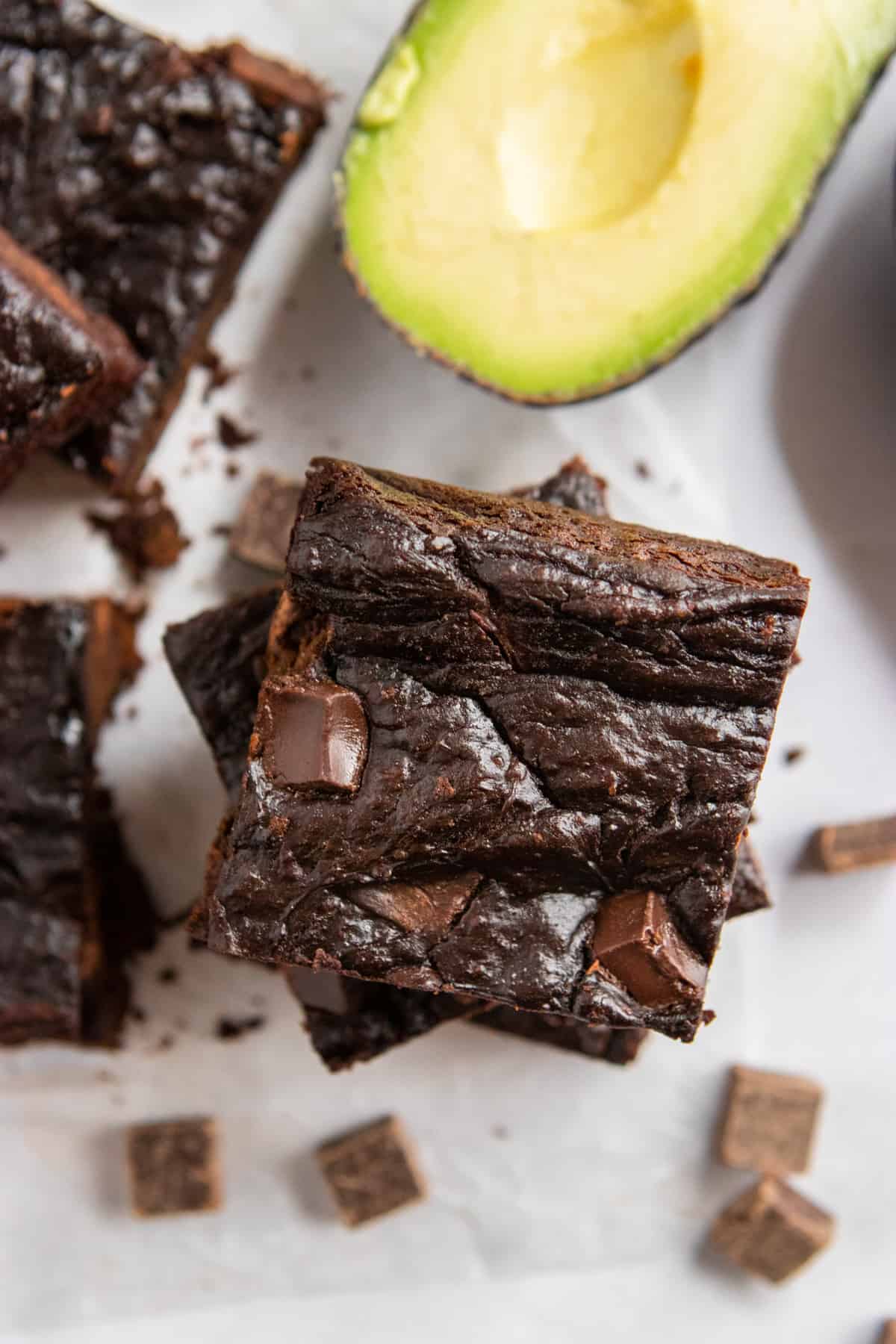 Stack of avocado brownies with cut avocado.