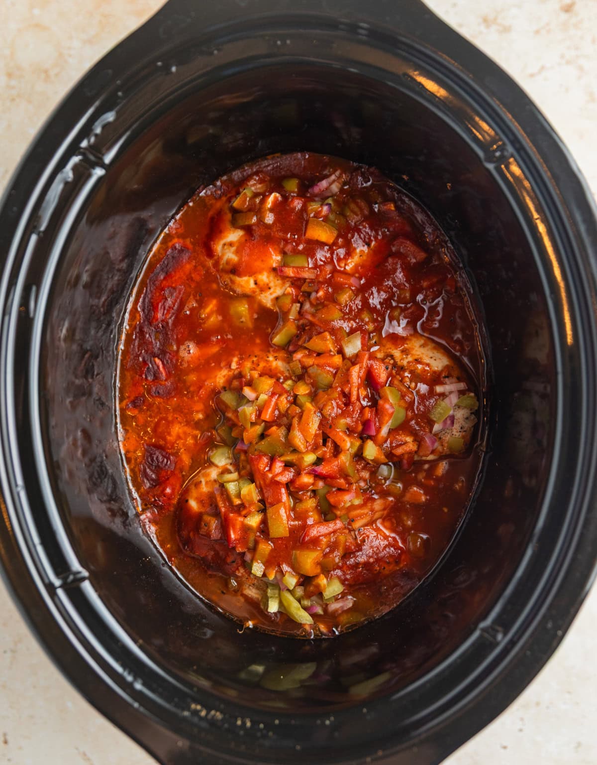 Cooked bbq chicken in slow cooker before shredding.