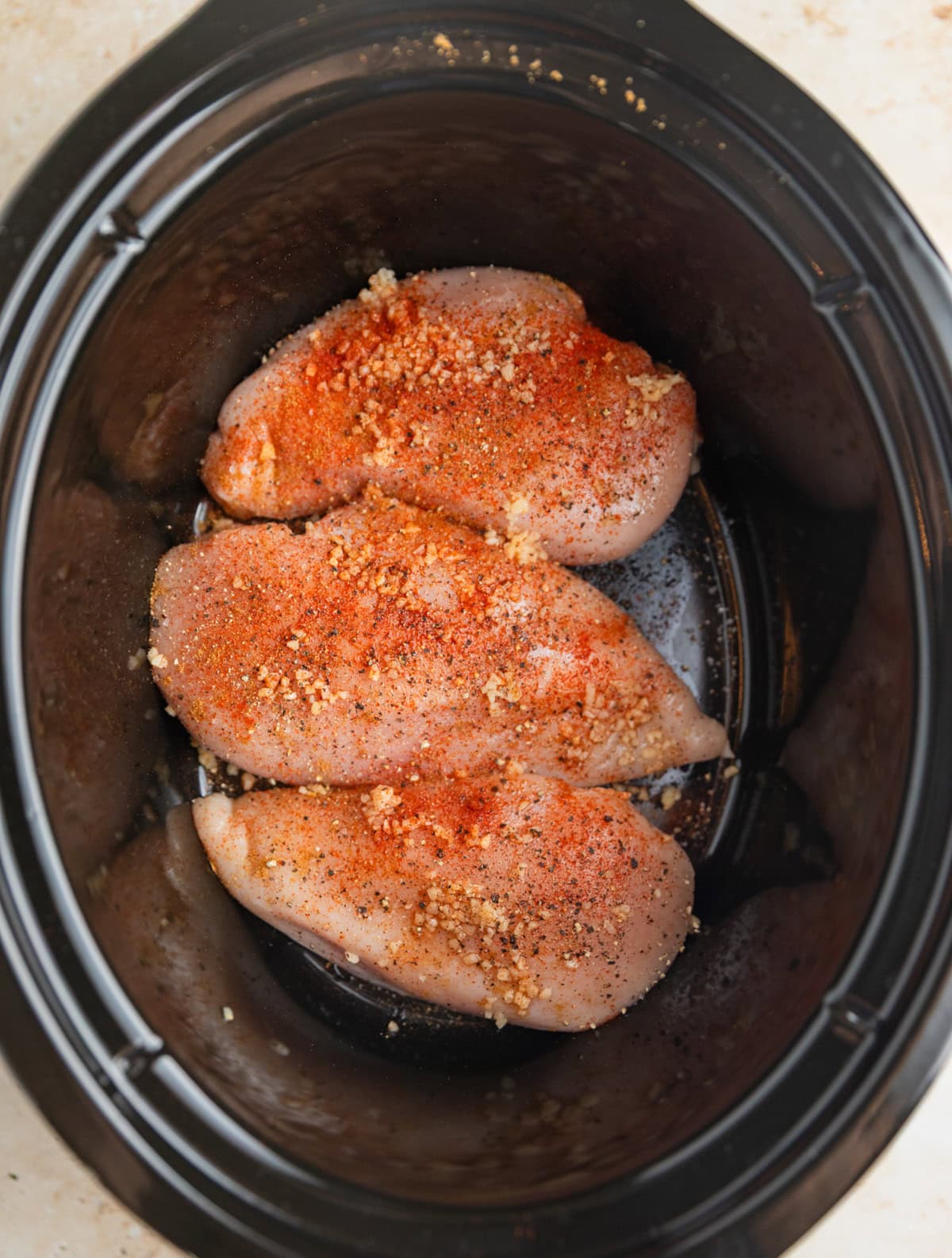 Seasoned chicken breast in crockpot.