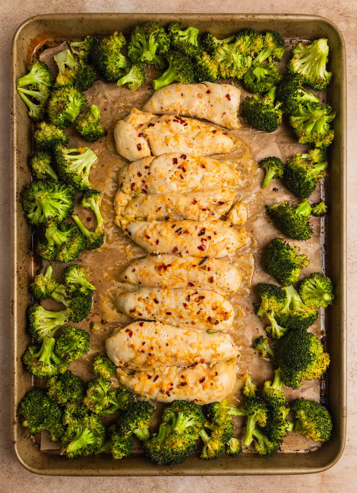 Baked orange chicken sheet pan dinner after being baked with cooked broccoli.