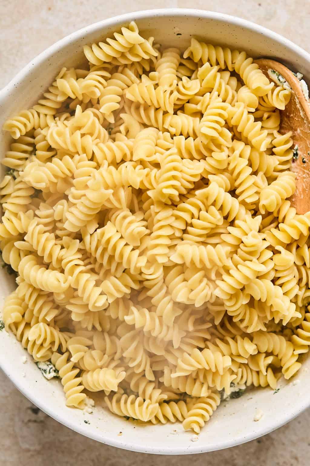 Cooked rotini pasta in strainer.
