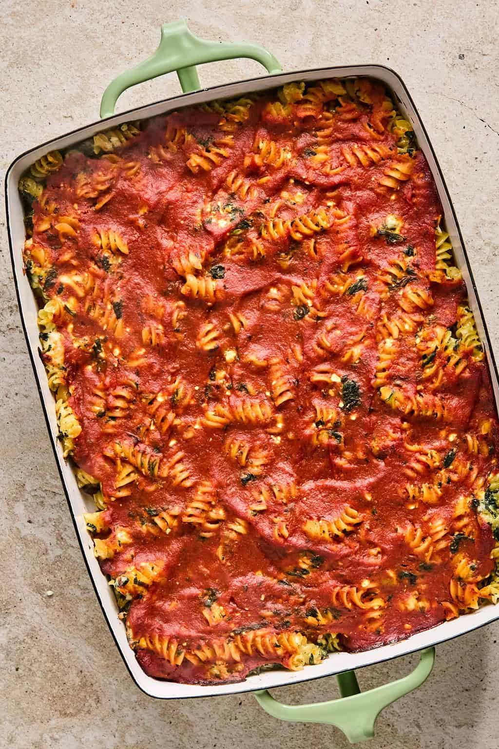Baked pasta with spinach topped with marinara.