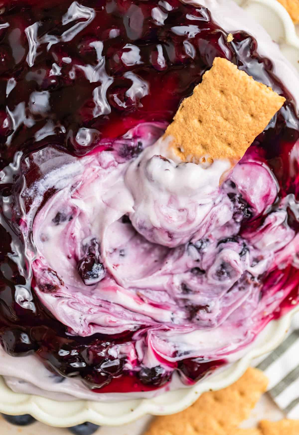 Graham cracker dipped in blueberry cheesecake dip.