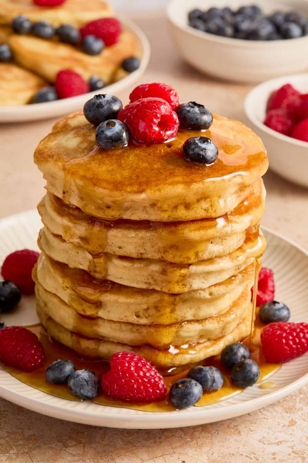 Stack of dairy free buttermilk pancakes topped with syrup and berries.