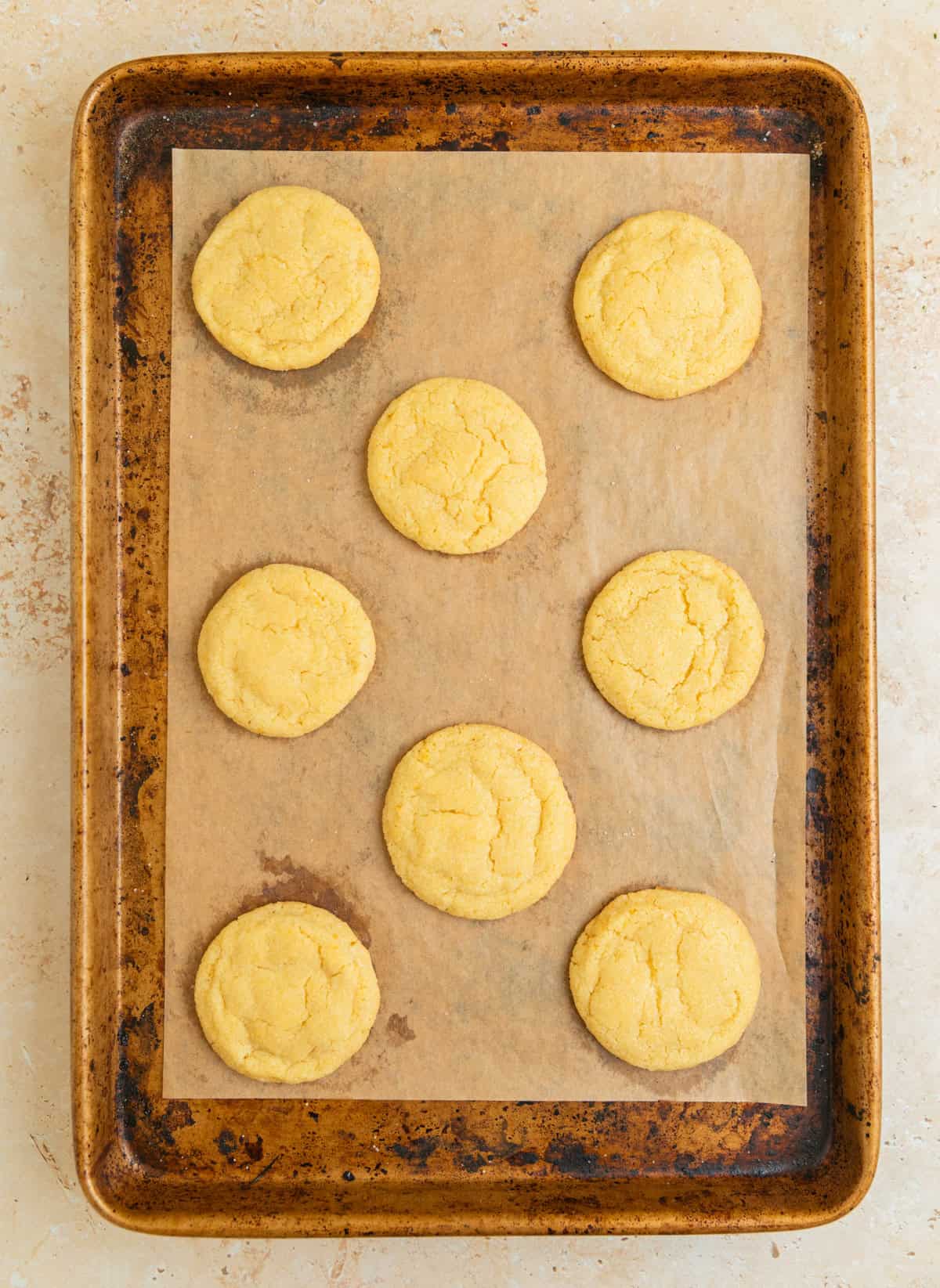 Baked lemon cookies fresh from oven on baking sheet.