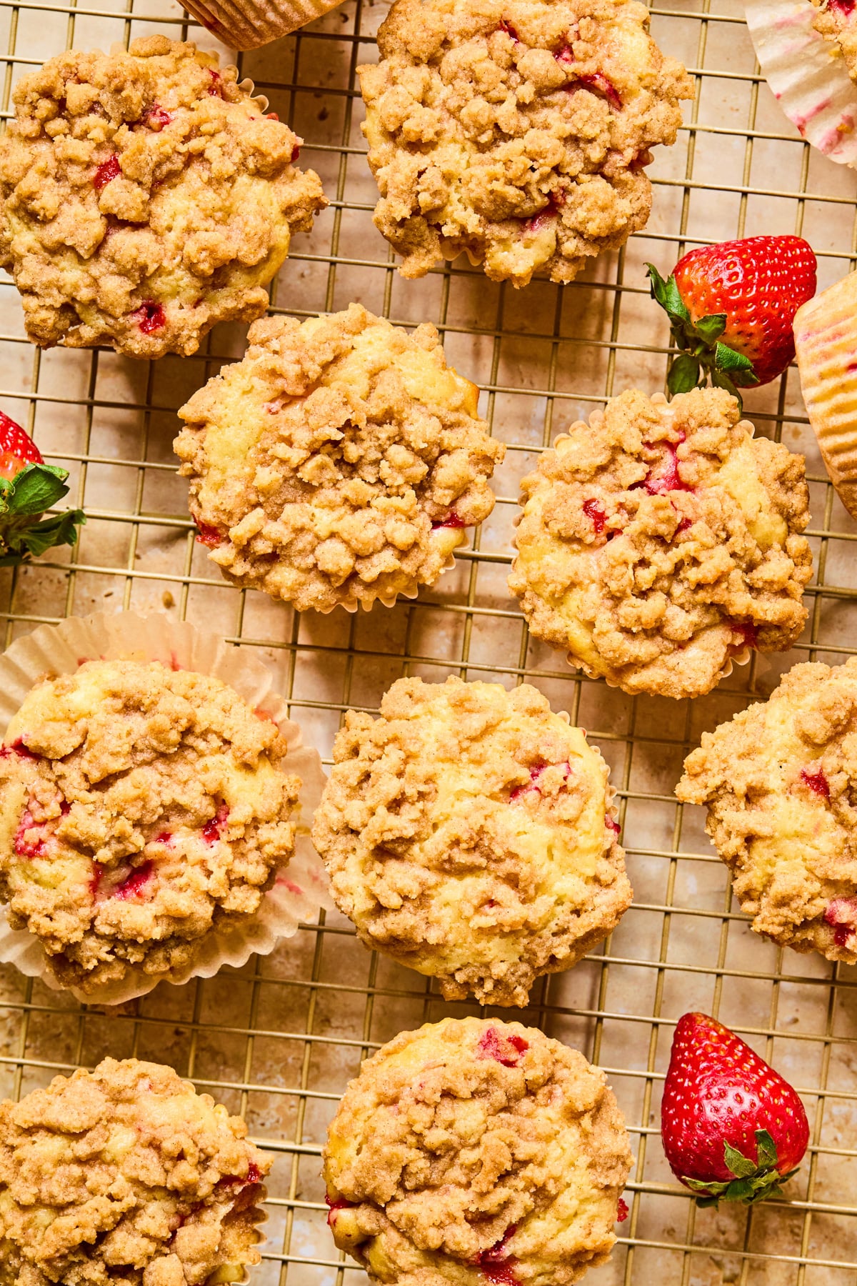 Strawberry muffins with crumble topping on wire rack.