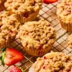 Strawberry muffins with crumb topping on wire rack.