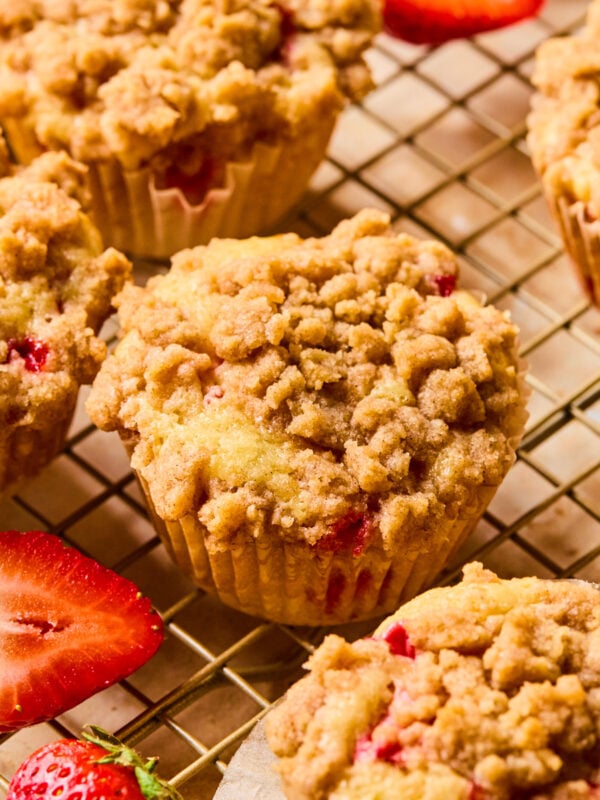 Strawberry muffins with crumb topping on wire rack.