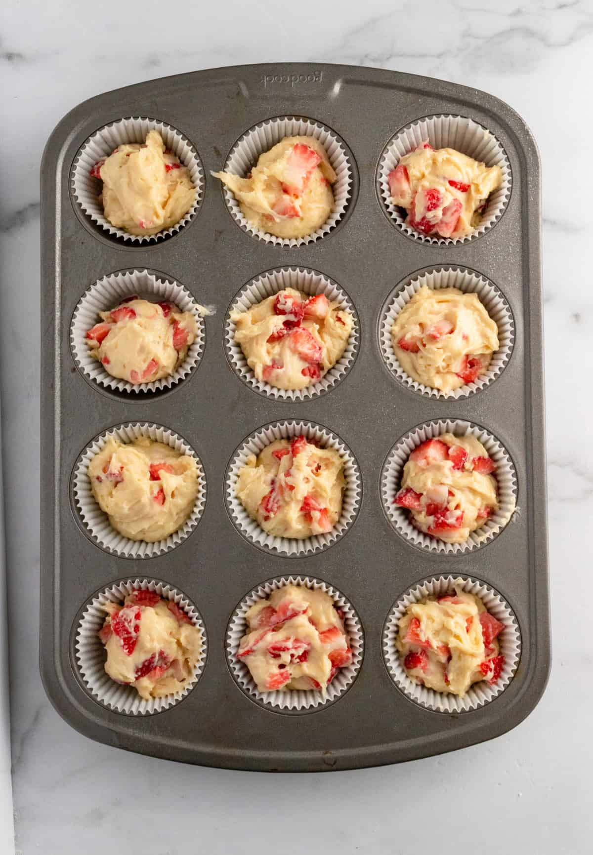 Strawberry muffins in pan before crumb topping added.