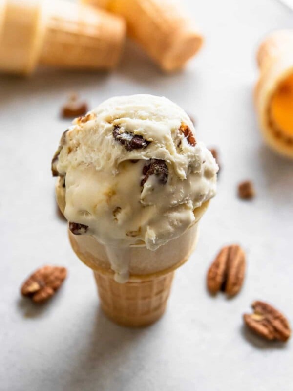 butter pecan ice cream cone with pecans beside it.