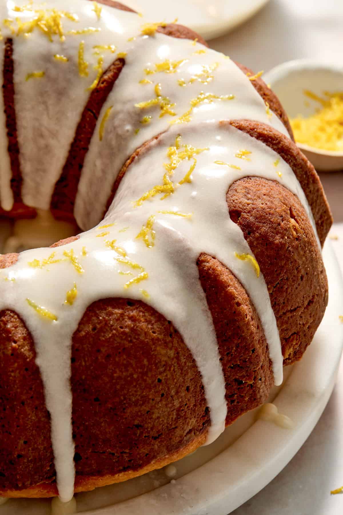 Champagne lemon bundt cake with lemon icing drizzled over top and lemon zest.