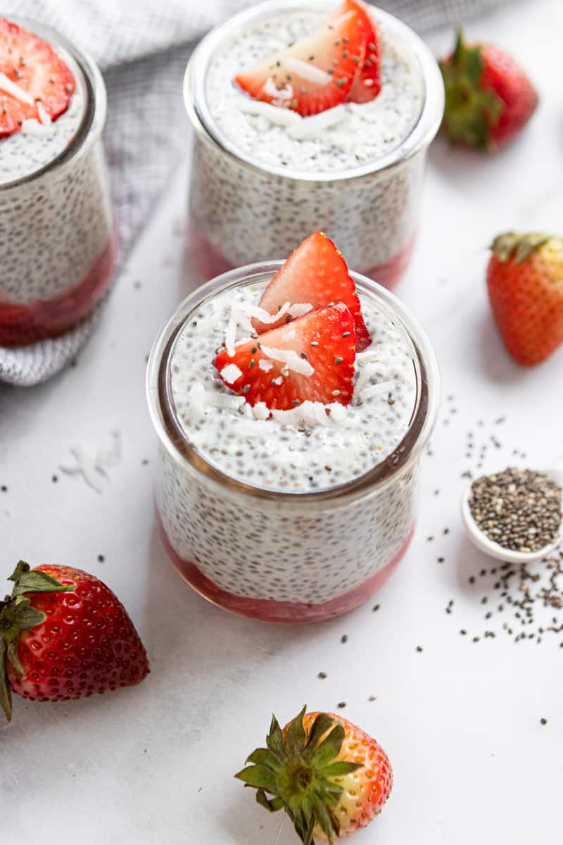 Chia pudding in a jar with coconut and strawberries on top.