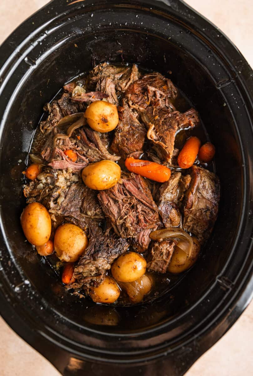 Chunks of meat, cooked carrots, onions and petite potatoes in slow cooker.