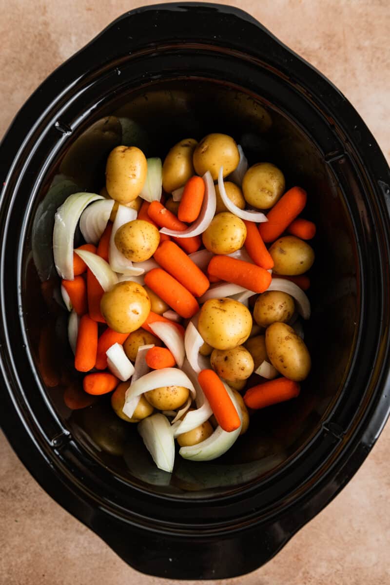 Carrots, onions and potatoes in crock pot.