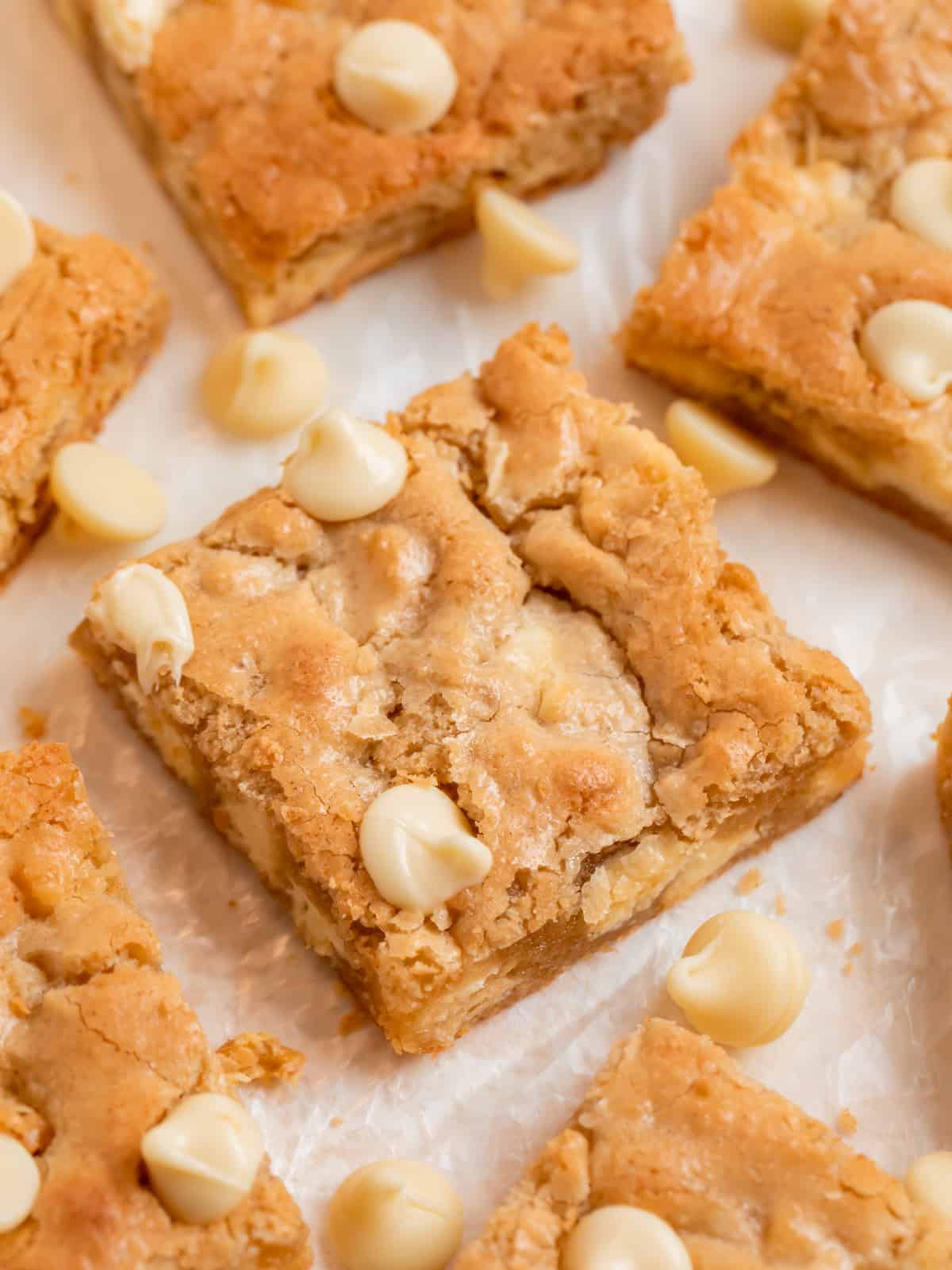 Almond flour blondies lined on wax paper with white chocolate chips.
