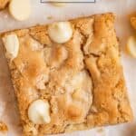 Gluten free almond flour blondies with white chocolate chips sliced in squares on wax paper.