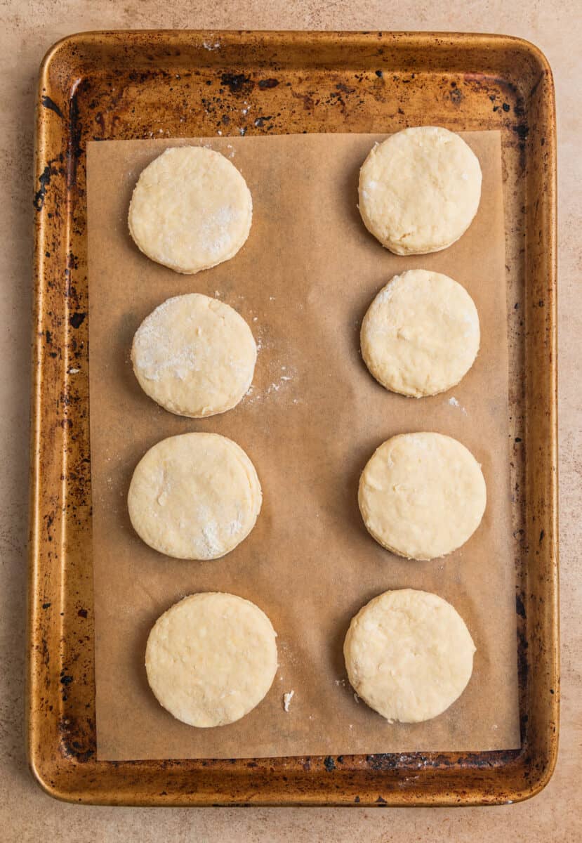 Biscuits lined on parchment lined baking sheet.